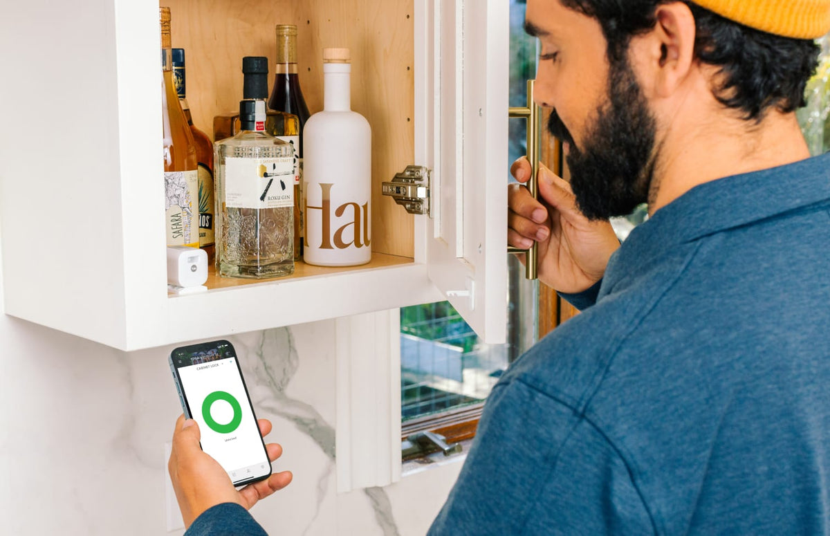 Man opening Yale Smart cabinet with easy remove access via iPhone 