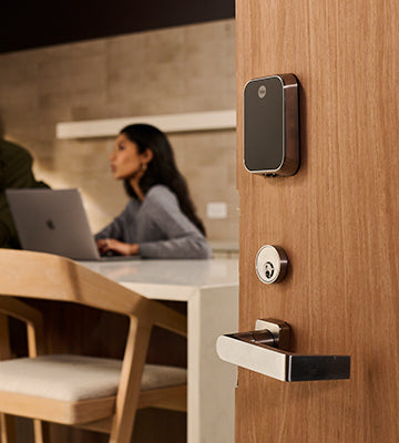 Yale Pro Lock with a woman working at a laptop in the back at a conference table